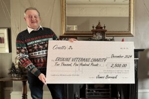 Man holding 2,500 Erskine Veterans Charity check.