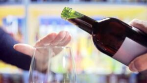 Hand rejecting wine pour into glass.