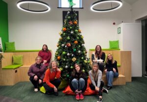 Team Christmas photo by the tree.