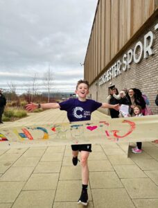 Boy finishes Cancer Research UK race.