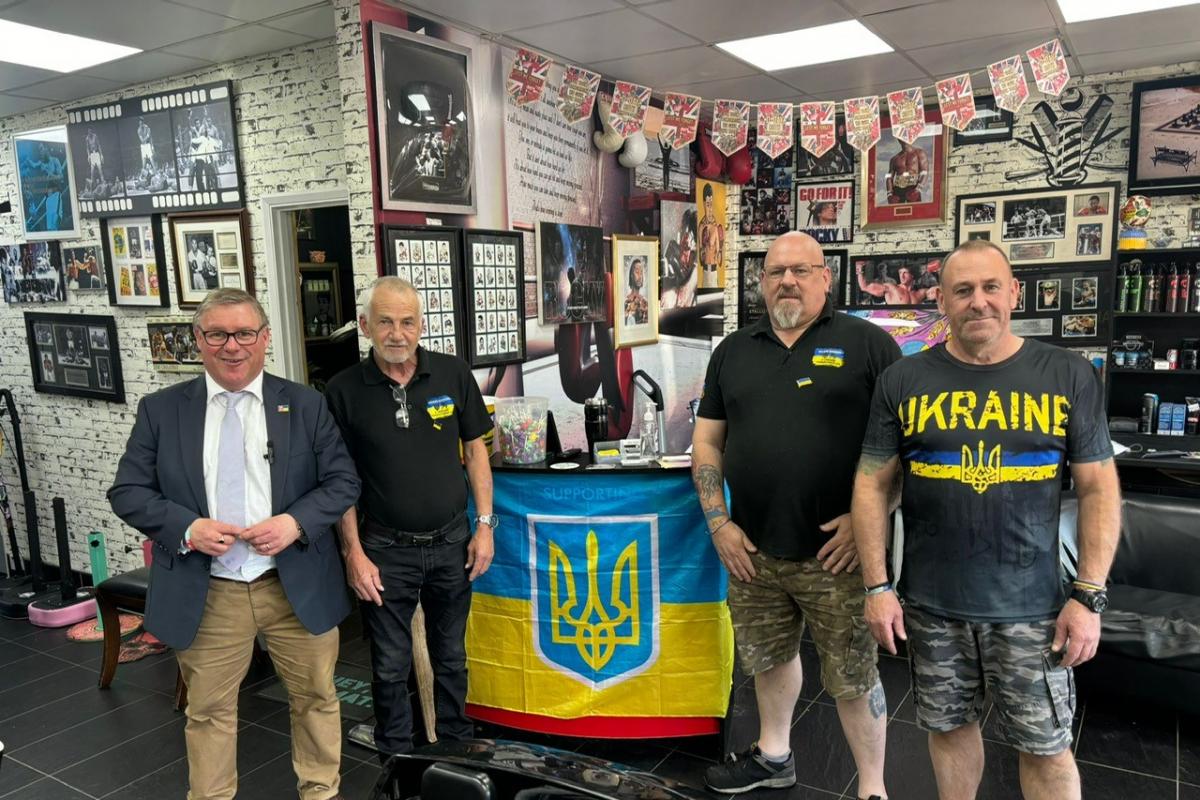Four men supporting Ukraine with flag.